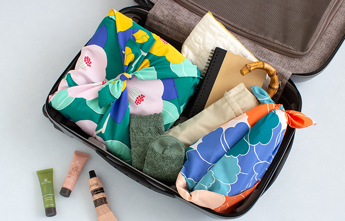 70アクアドロップ キャリーケースの荷物を風呂敷で包んで仕分けしている様子