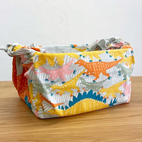 いろいろな恐竜のふろしきで収納ボックスを包んだイメージ