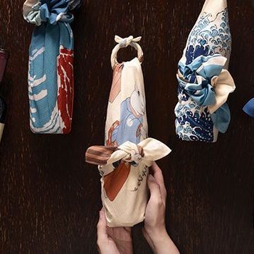 70 隅田川 流行猫の曲手まり クリーム 猫が手まり蹴って遊んでいる様子のふろしきでワインボトルをラッピングしている