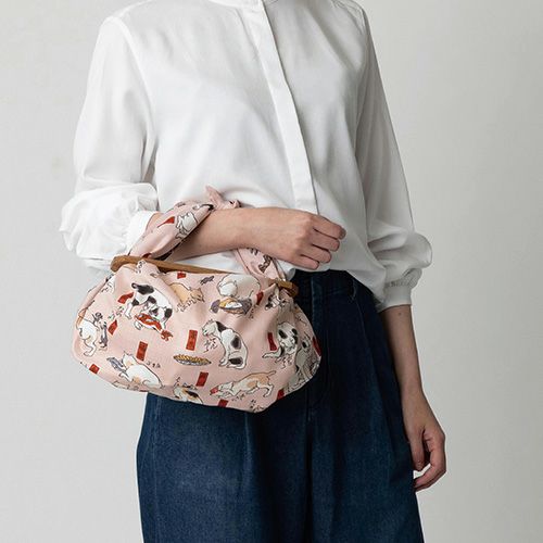 70 隅田川 猫飼好五十三疋 ピンク　洋服と合わせてふろしきパッチンバッグをもっている様子