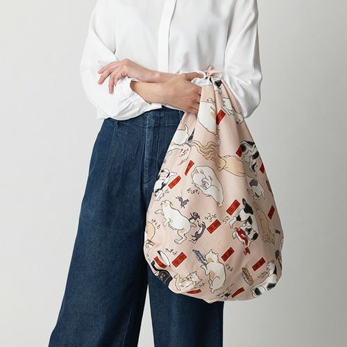 三巾 隅田川 猫飼好五十三疋 ピンク　洋服と合わせてふろしきパッチンバッグをもっている様子