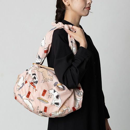 三巾 隅田川 猫飼好五十三疋 ピンク　洋服と合わせてふろしきパッチンバッグをもっている様子